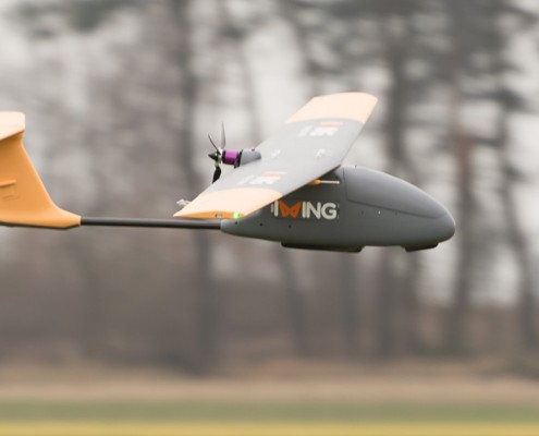 dron płatowiec lecący nad ziemią