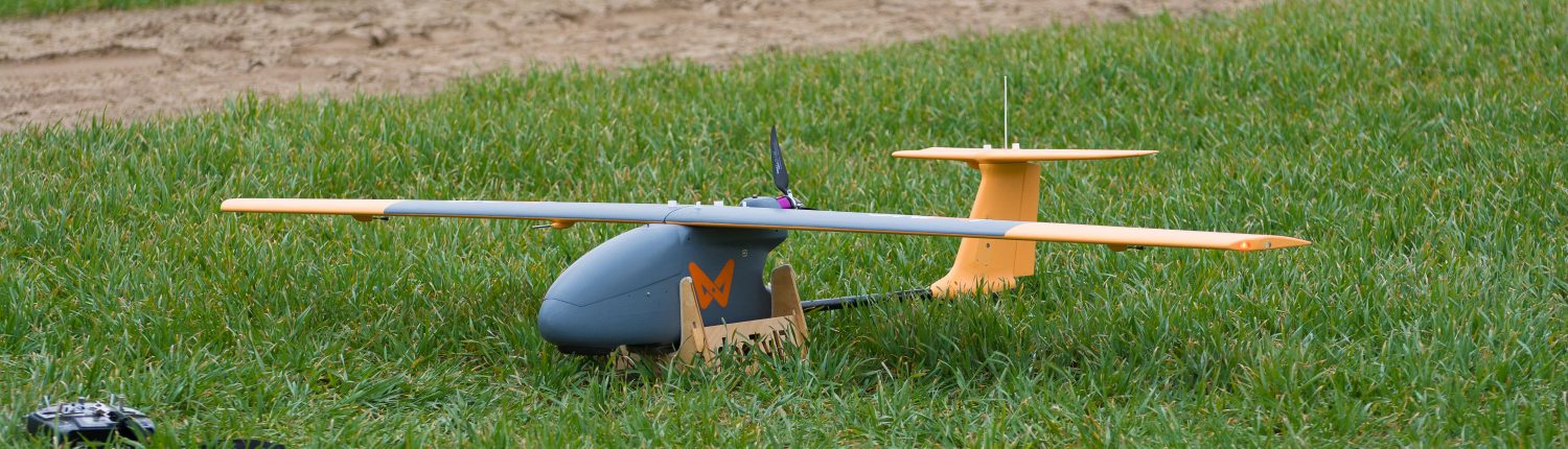 dron samolot po wylądowaniu na zielonej trawie