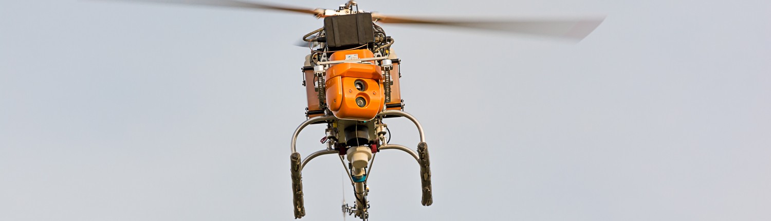 dron helikopter w czasie lotu na tle lekko zachmurzonego nieba